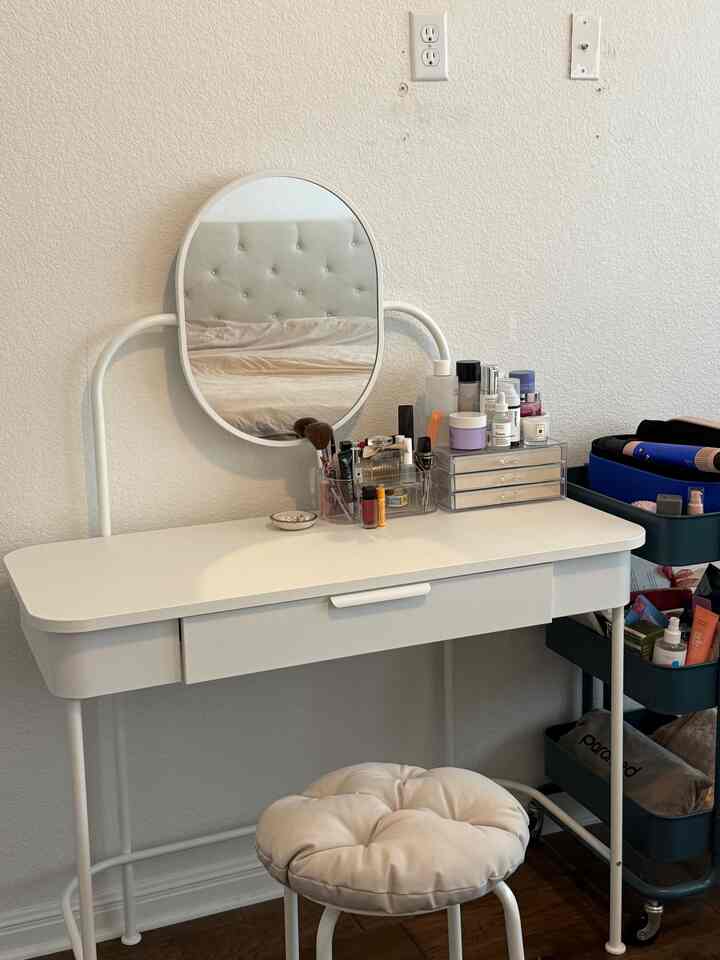 White-toned small room vanity featuring a minimalist dressing table and cushioned stool creating a cozy atmosphere