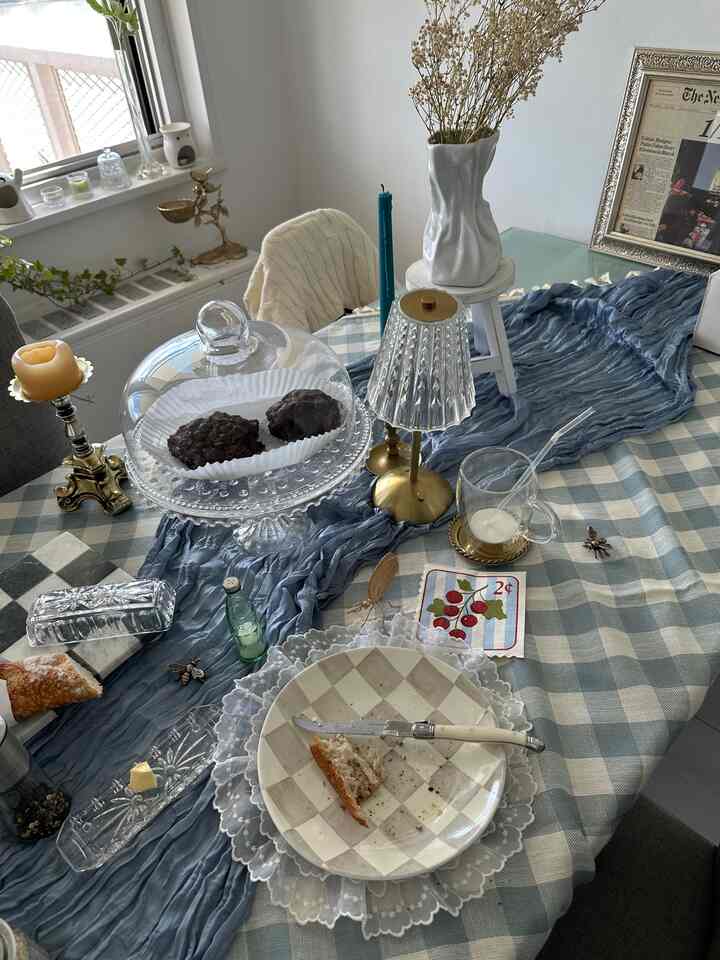 White and gold toned dining room featuring a vase with dried flowers and glassware in a French Country style table setting
