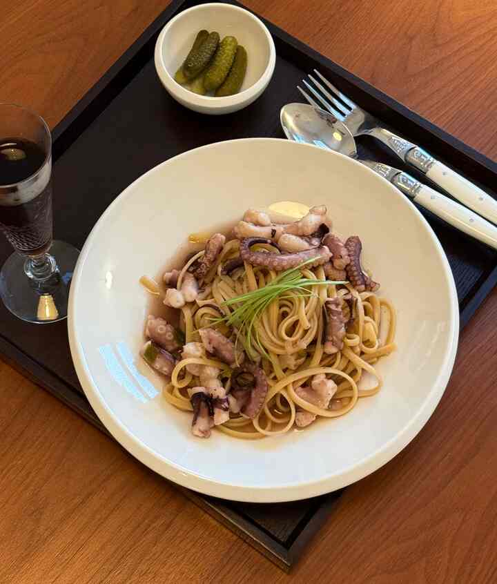 Warm wood-tone dining table featuring classic white tableware and cutlery set for a single-person dinner setup