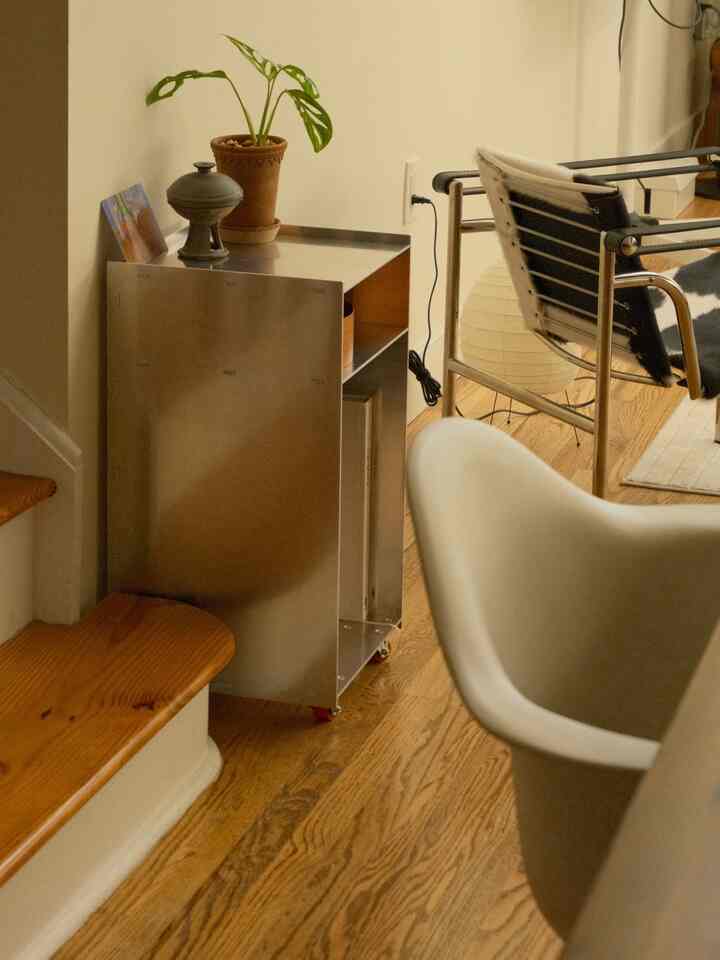 This is where the dining table used to be, against the wall next to the staircase. Instead, I out an aluminum cart here and it stores all of my tea supplies and cookbooks.

#cart #storagecart #terracottapot #loungechair 