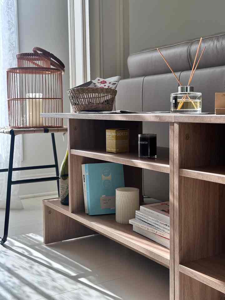 Warm brown-toned entrance space featuring wood-tone side table and sofa, creating a cozy atmosphere