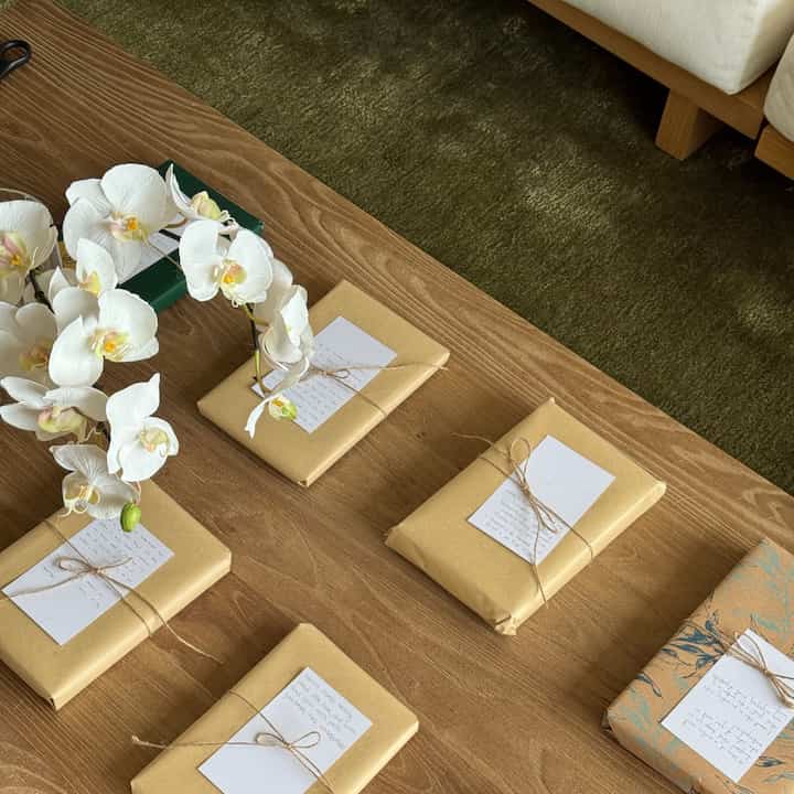 Natural-toned living space featuring a wooden dining table, olive rug, and white sofa creating a harmonious atmosphere