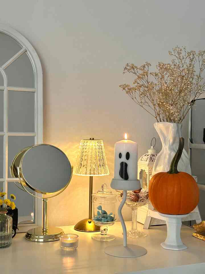 Beige and white toned entrance space featuring seasonal decorations like pumpkin and ghost candle, creating a warm cozy atmosphere