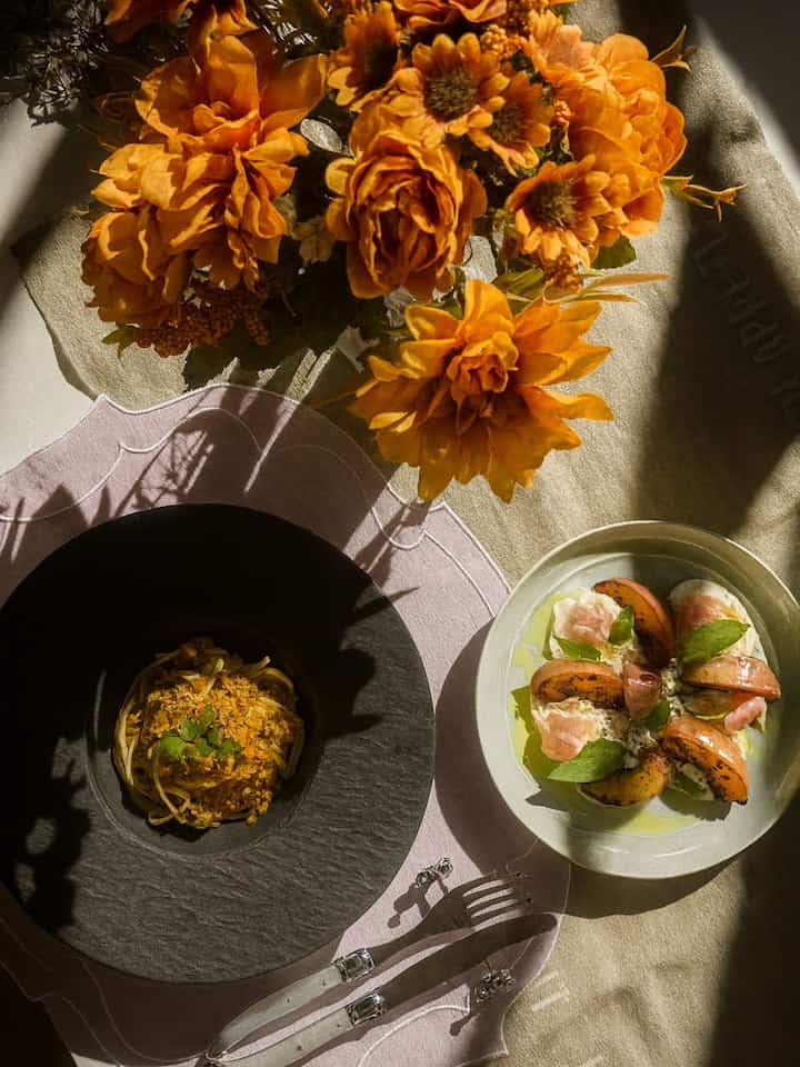 A cozy table set with autumn blooms, fresh pasta, and a burrata salad

#TableDecor #AutumnVibes #PastaLove #GourmetLife #CozyDining #FoodieMoment 