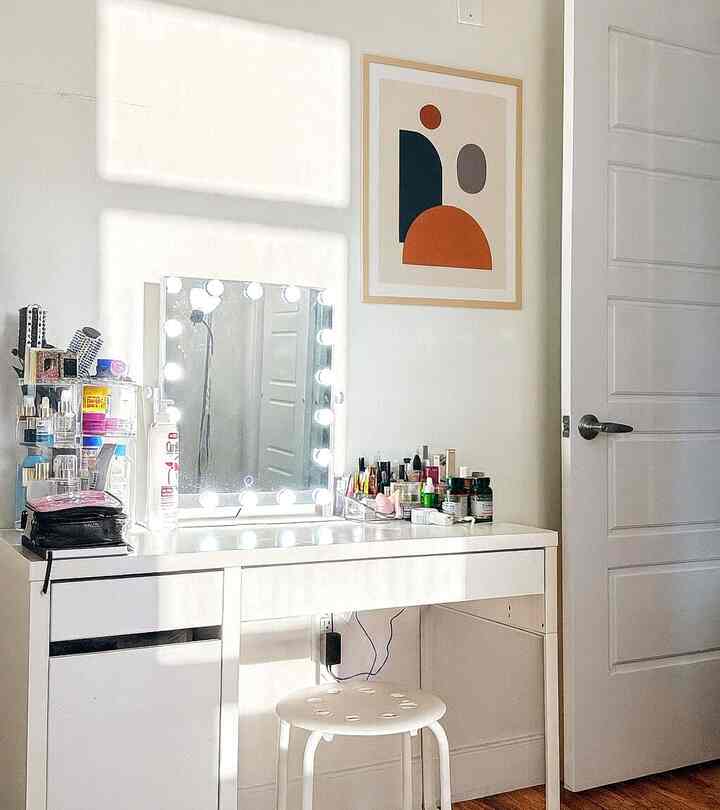 Bright white corner room featuring illuminated vanity, stool, and organized makeup essentials creating a clean fresh atmosphere