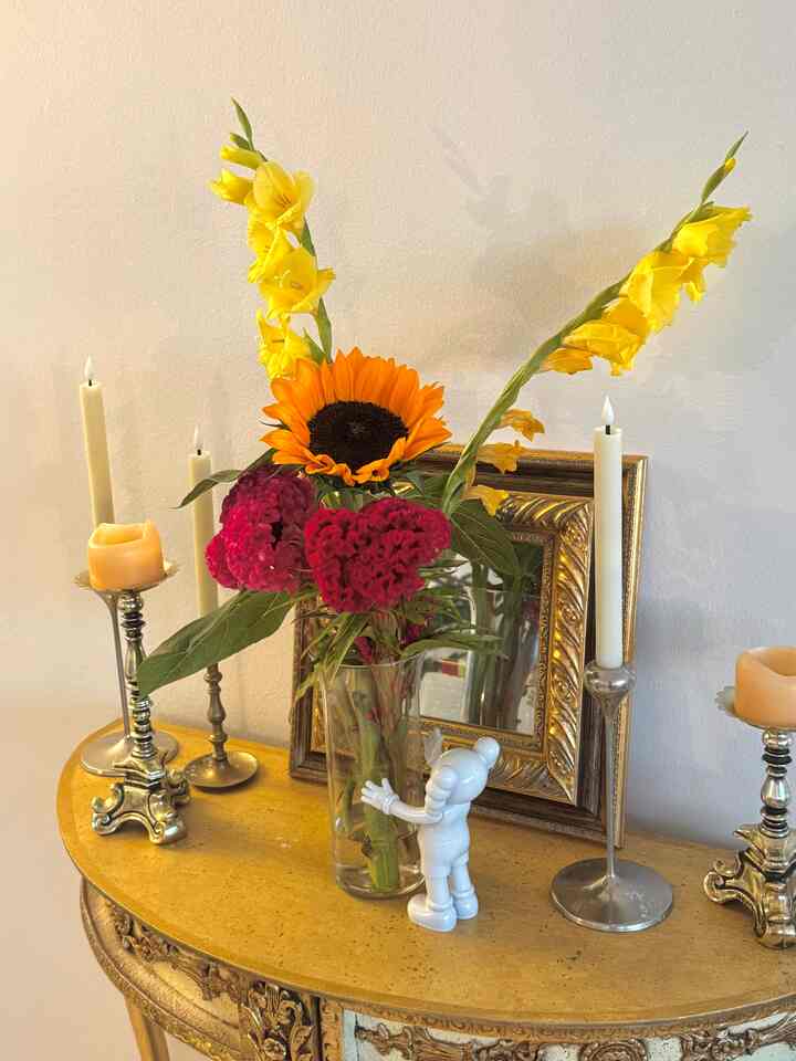 Yellow flowers and gold accents on a French Country style side table with romantic candle decorations