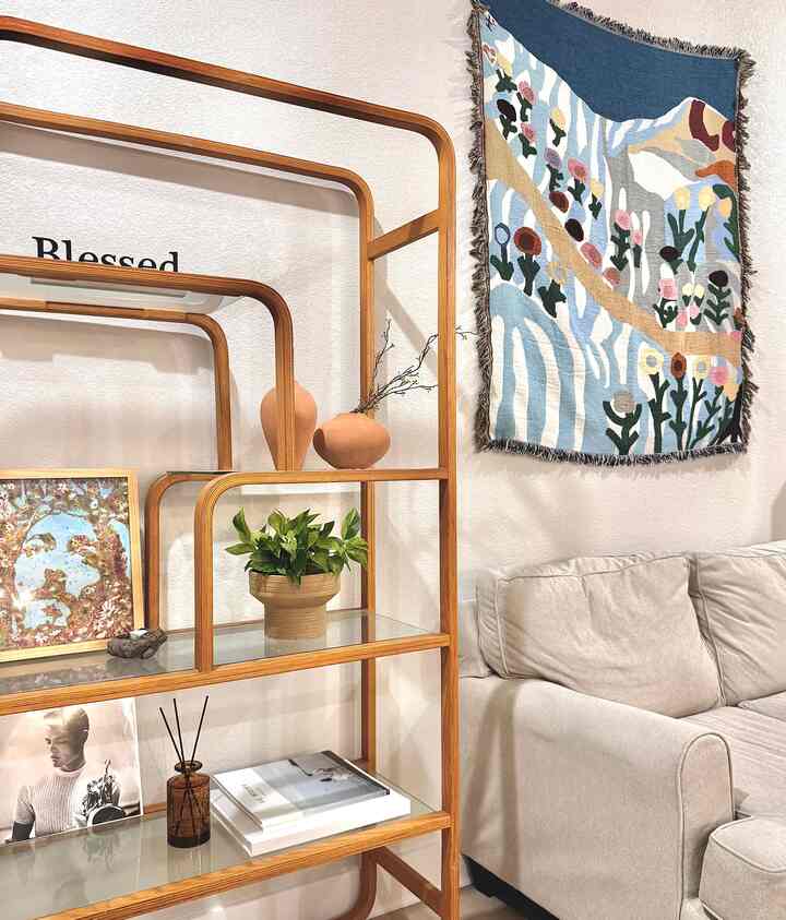 Beige and wood tone living room featuring natural wood shelf and fabric sofa creating a cozy atmosphere