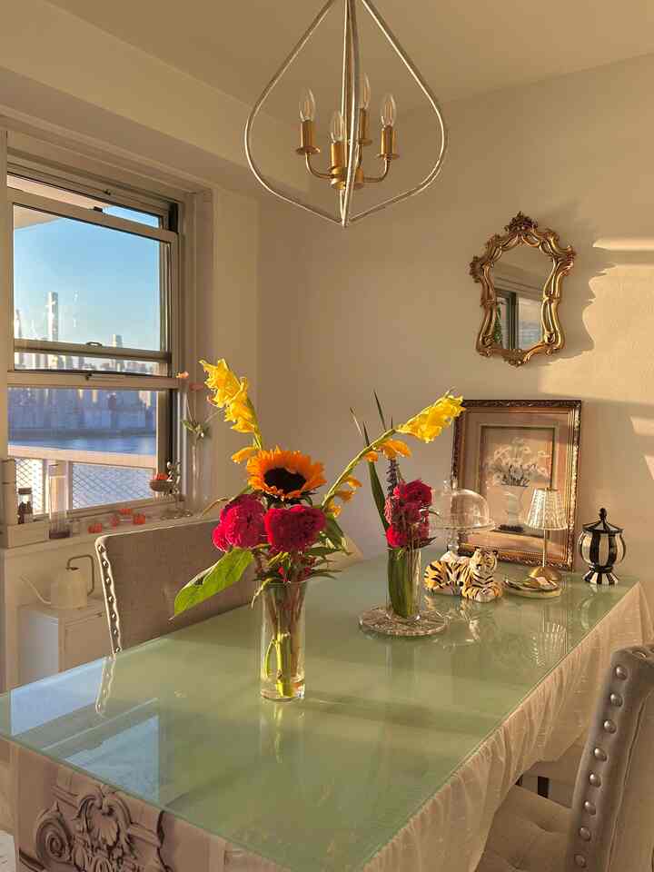 Gold-accented dining room for 4 with a transparent glass table, featuring modern French country style vases and decorative accents