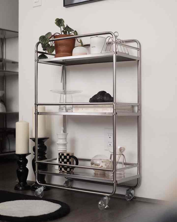 Silver stainless kitchen cart against white wall and floor, featuring mid-century modern style with a minimal atmosphere