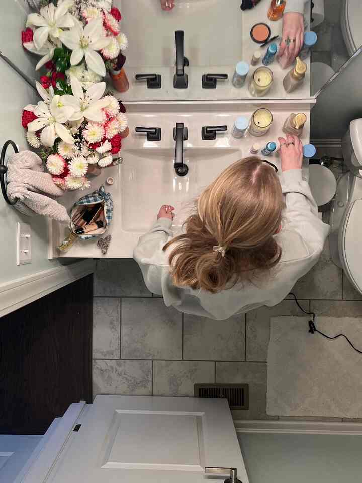White and black toned bathroom featuring sink, towels, and candle decor with a clean organized atmosphere