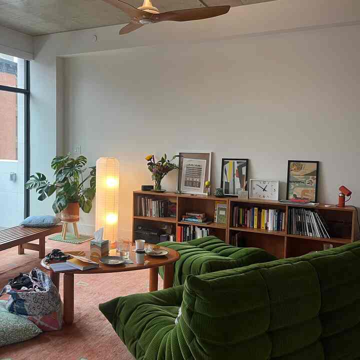 Natural tone living room featuring green sofa and wooden coffee table with cozy atmosphere
