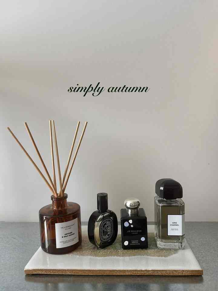 Natural-toned entrance space featuring various diffusers neatly arranged on an Ikea shelf, evoking autumn mood