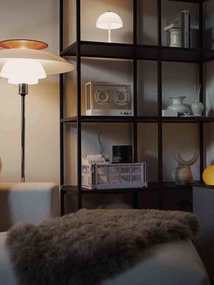 Beige and dark brown tone living room featuring floor lamp, open shelving, and fur throw in a modern natural modern style space