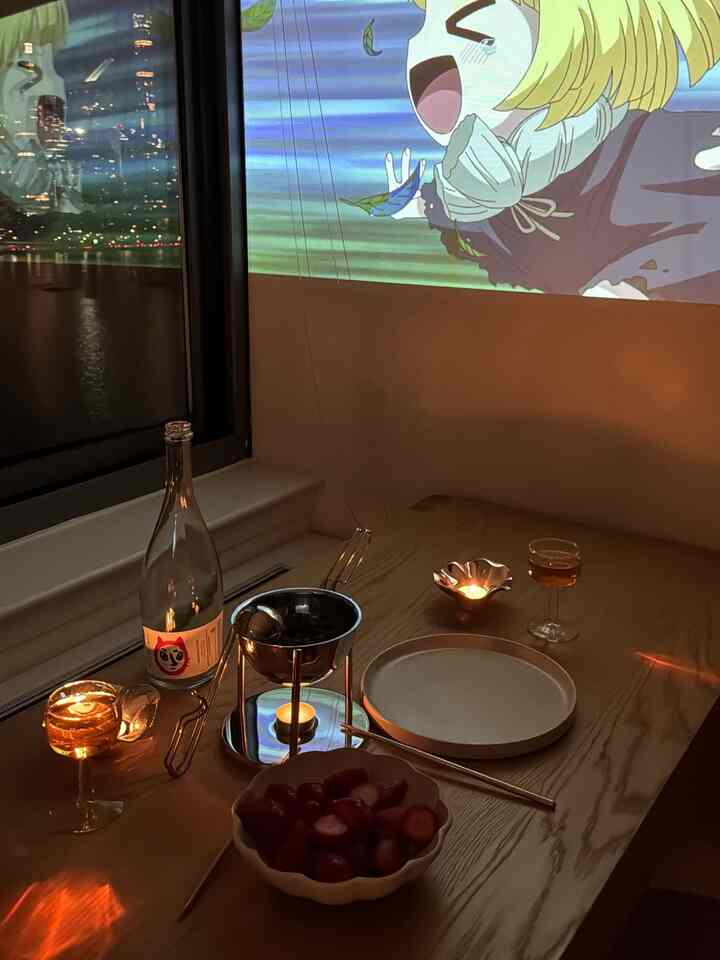 Warm brown-toned dining room featuring candles and a projector for a cozy home date atmosphere
