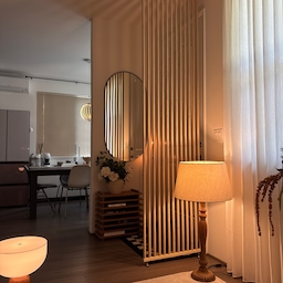 View seen from the couch!! 
The shadows from the slatted partition create such a stylish vibe.
#entrance #livingroom #diningroom #lamp #partition #vase #flower #lighting #rug #mirror #wallmirrior #ikea #lightinginterior #moodlighting #falldecor #fallinterior 