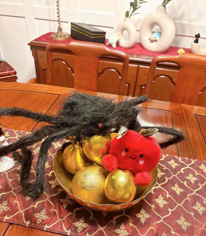 Dining room with red and gold tones featuring decorative objects and a table runner on a wooden dining table creating a cozy atmosphere