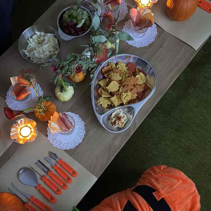 Cozy home party setting on green carpeted floor with brown table runner and assorted bowls on wooden table