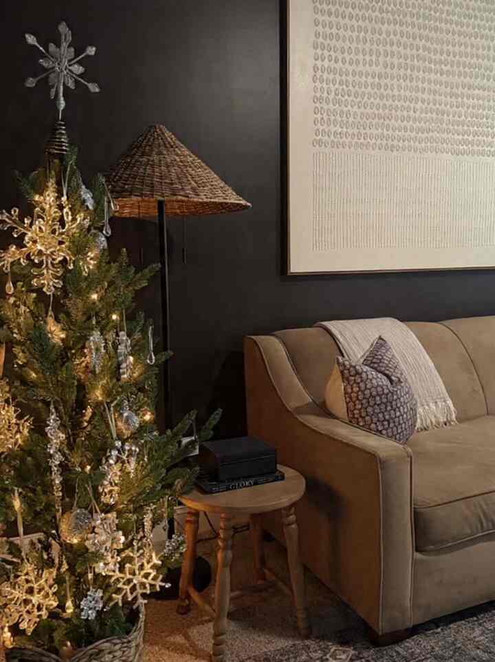 Warm brown and natural-toned living room corner featuring a Christmas tree and string lights creating a cozy atmosphere