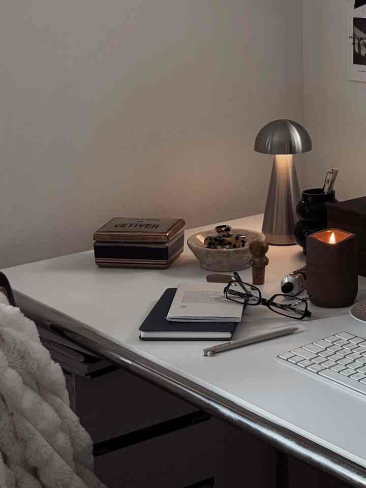 White-toned home office space featuring a Mid-Century Modern silver desk lamp and clean desk creating a cozy workspace