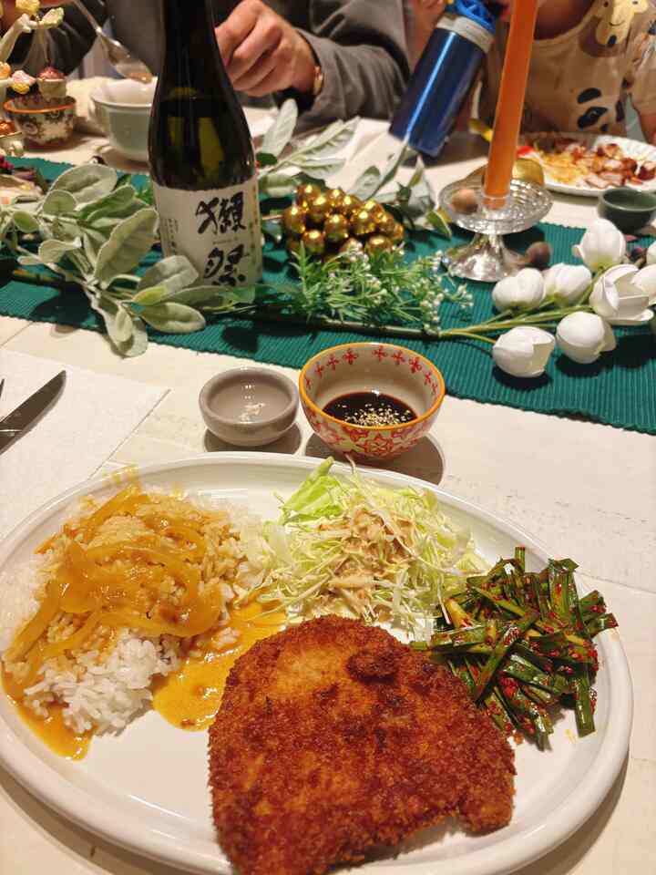 A white and green toned dining room featuring a Korean-Japanese fusion meal and decorative candles on the dining table in a cozy home party setting