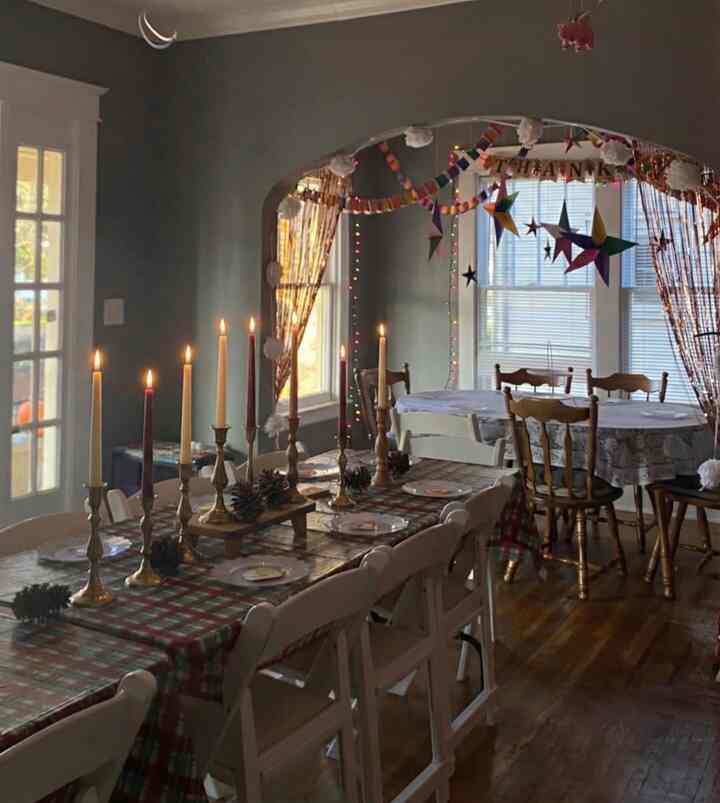 Cozy brown and red-toned living room featuring long dining tables with candle holders for a home party setting