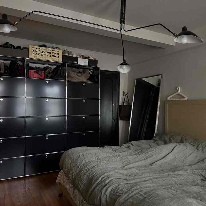 Gray and black toned bedroom featuring bedding and a USM storage cabinet with a modern, tidy atmosphere