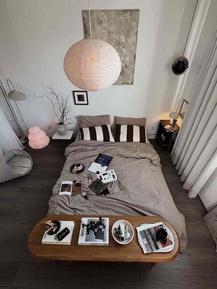 A brown and white toned bedroom featuring a centrally placed bed and a coffee table, creating a soft, calming atmosphere