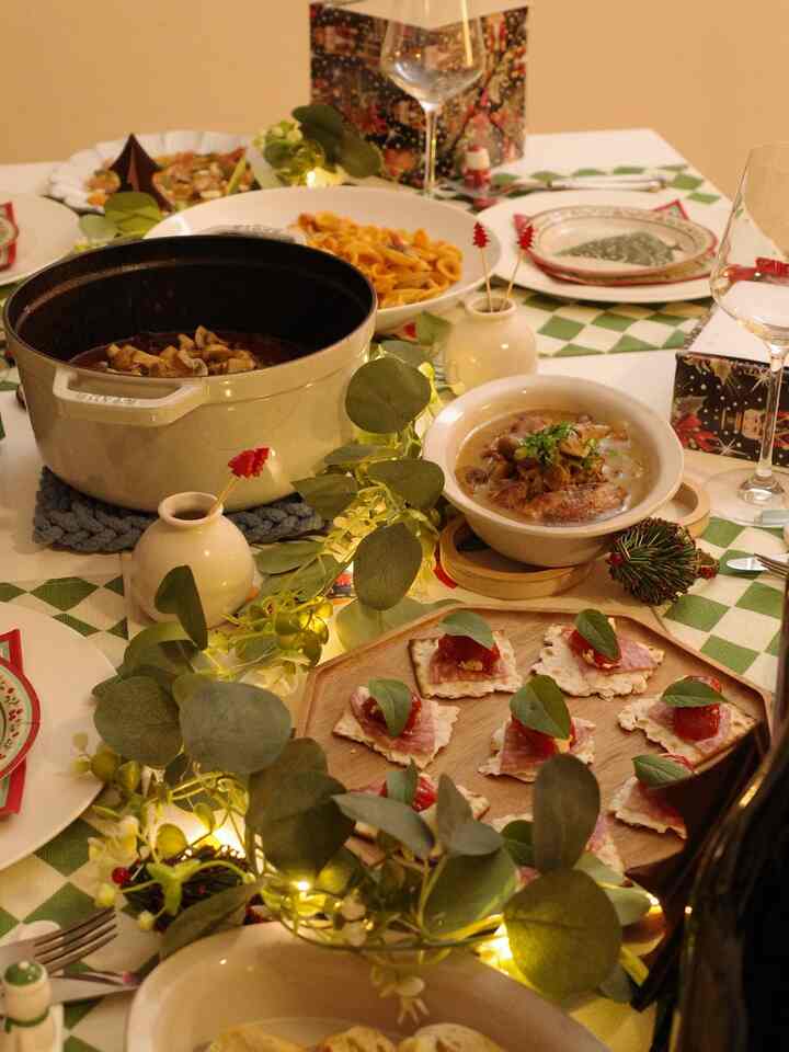 Warm gold-toned Christmas home party dining table featuring various dishes and decorations with a cozy home cafe atmosphere