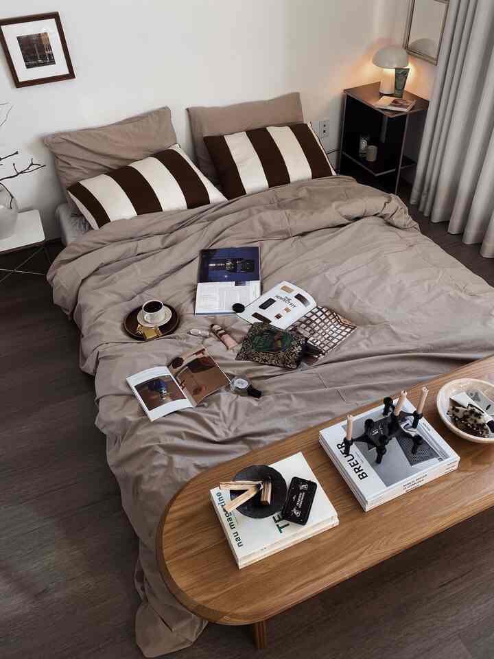 Soft beige and brown toned bedroom featuring a large bed and wooden bench creating a cozy atmosphere
