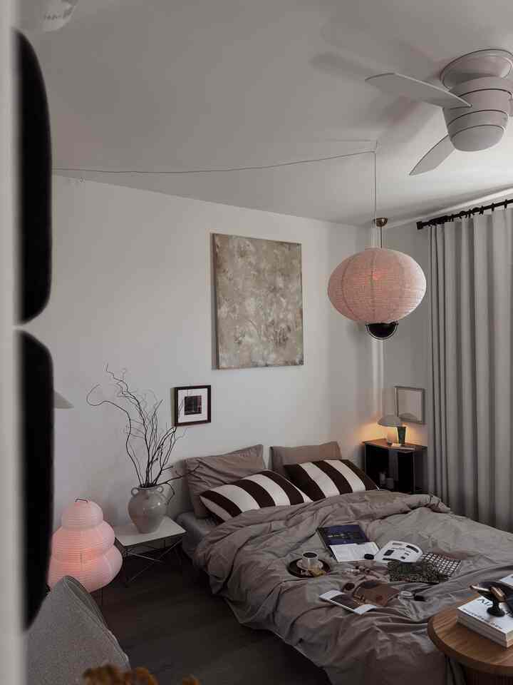 A beige and brown toned bedroom featuring a cozy bed and soft mood lighting creating a calm winter atmosphere