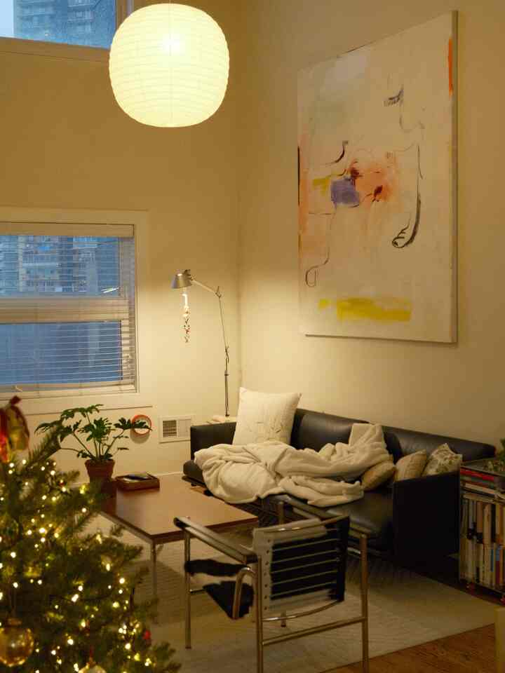 Ivory-toned living room featuring a black sofa, wooden coffee table, and a decorated Christmas tree creating a cozy atmosphere