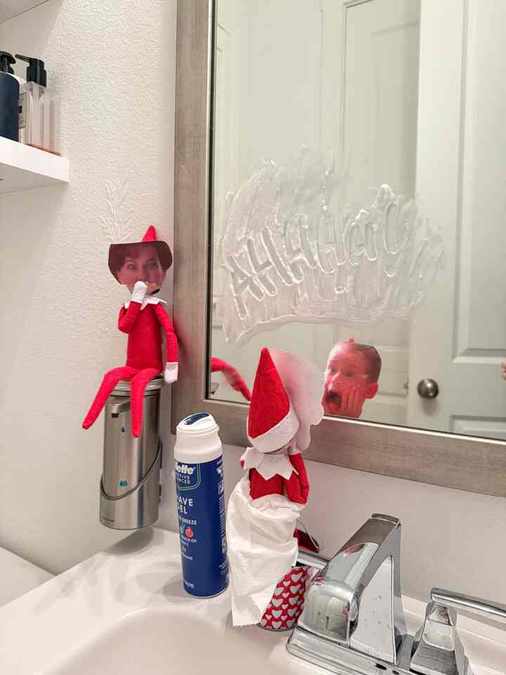 Simple white bathroom washbasin with mirror featuring cute red elf dolls as decoration
