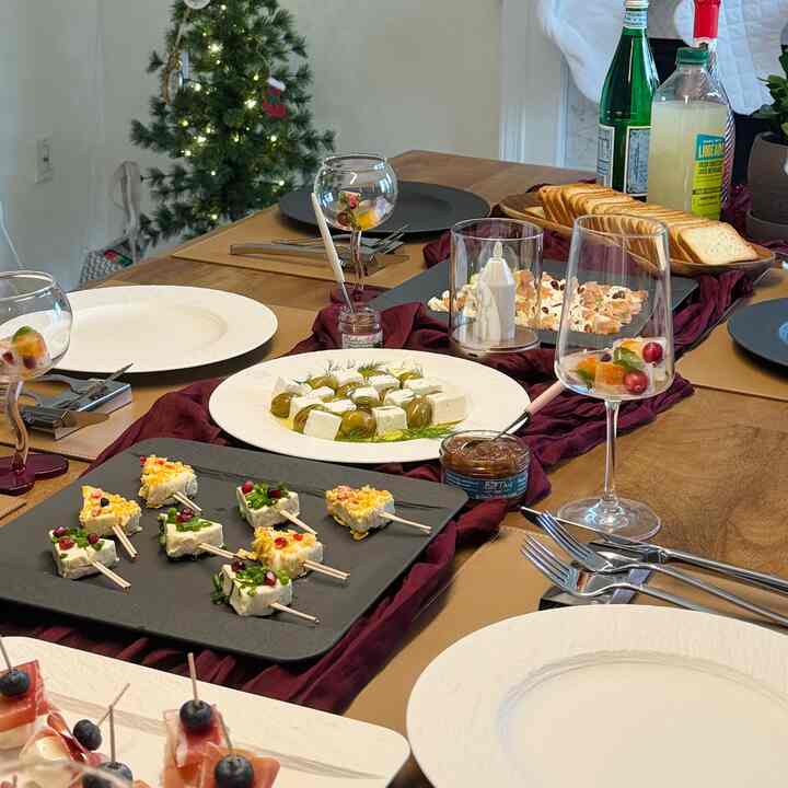 Warm brown and white toned dining room featuring a home party table set with Christmas decorations and assorted wine glasses