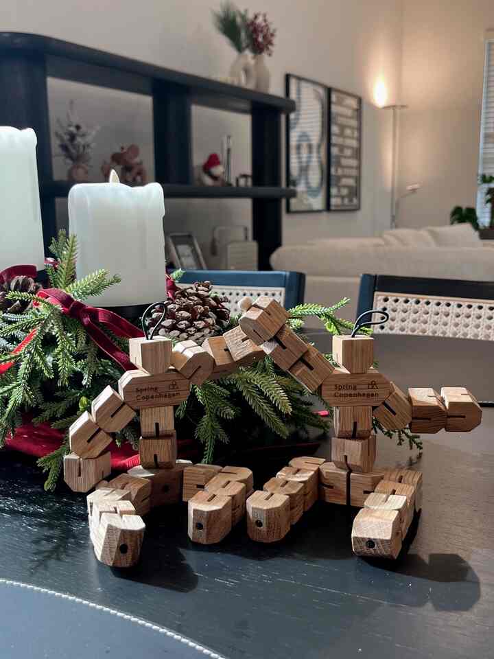 White and wood tone dining room featuring wooden figurines and candles on a modern dining table
