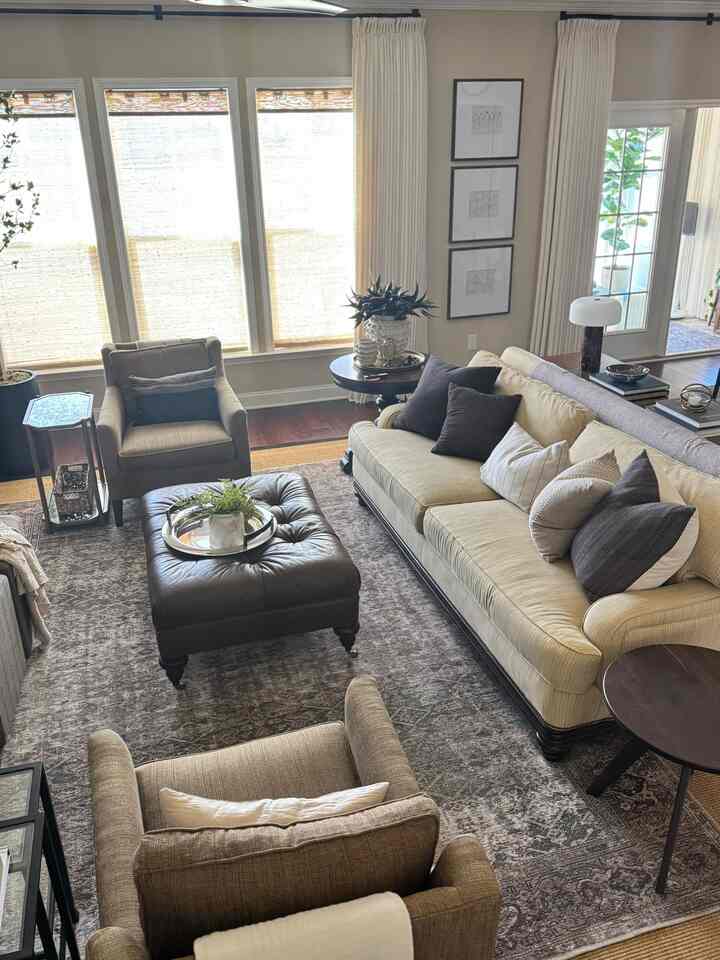 Natural-toned living room featuring a beige sofa, armchairs, and a vintage rug creating a cozy atmosphere