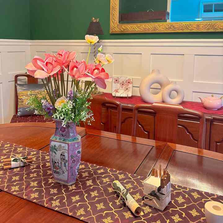 Brown wooden furniture and a pink vase in a vintage style dining room space