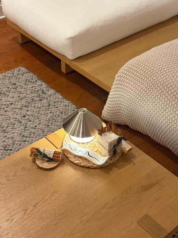 Natural wood tone minimal living room featuring a coffee table with candles and a table lamp, creating a cozy interior