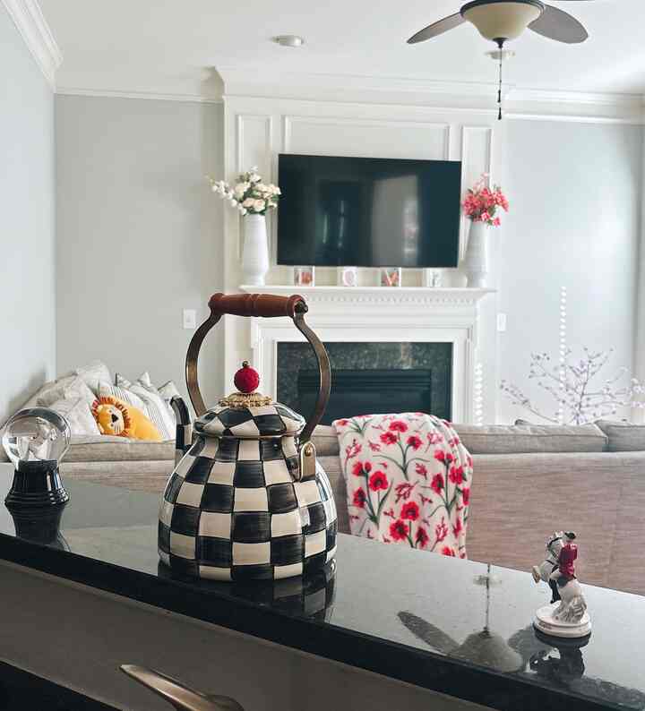 White and brown toned living room connected to kitchen, featuring cozy and warm cottage style interior