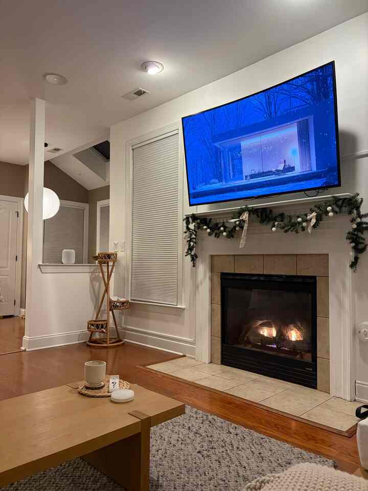 Natural wood tones and white walls harmonize in a living room featuring a fireplace and coffee table creating a cozy atmosphere