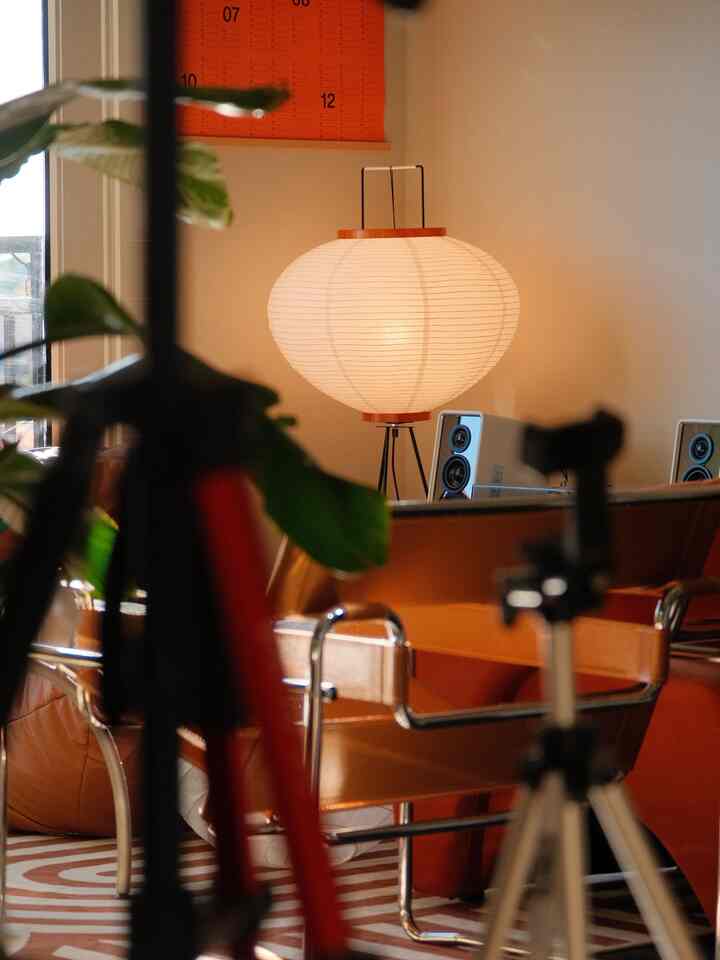 Warm and cozy living room featuring orange armchair and paper floor lamp with ambient lighting