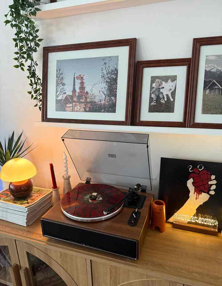 Natural wood tones and white walls frame a living room featuring a retro turntable and analog music setup
