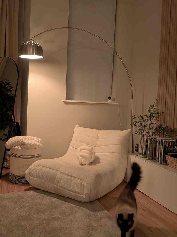 Natural color tone living room featuring cream Togo sofa and chrome arched floor lamp with a cozy atmosphere