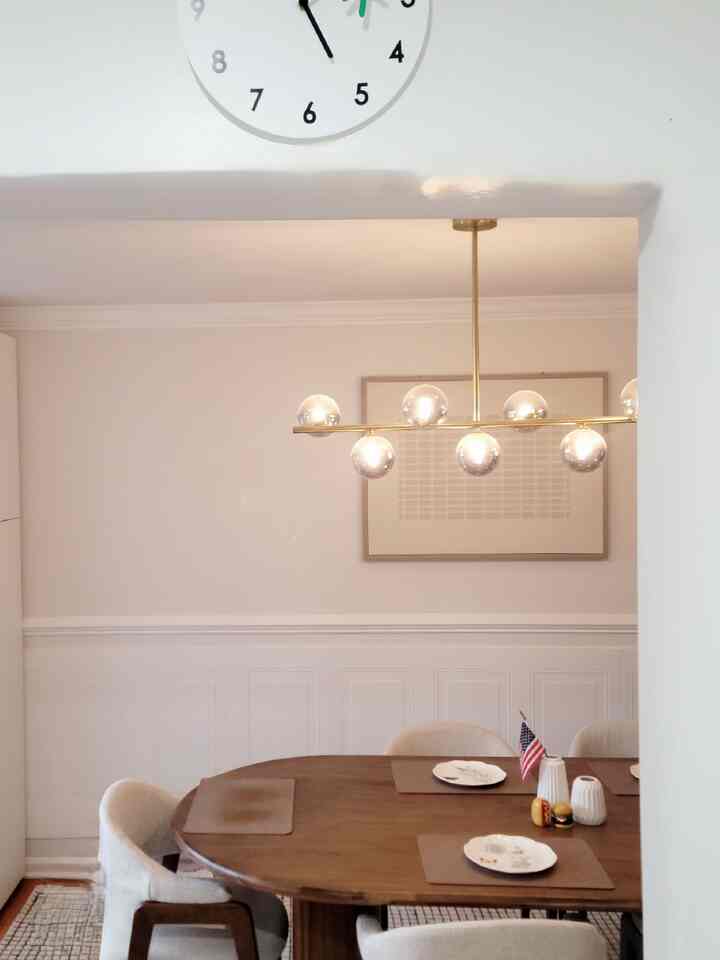 A simple modern dining room with a brown wooden dining table and white walls blending harmoniously