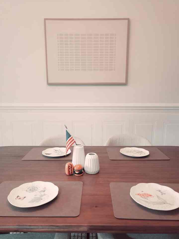 Soft beige and brown toned dining room featuring a wooden dining table with patterned plates arranged elegantly