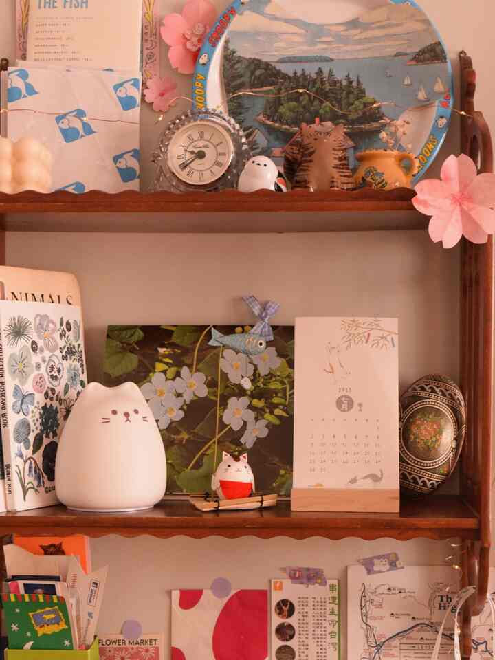 Cozy bedroom shelf with brown wood tone featuring cat-themed decorations and various decor items