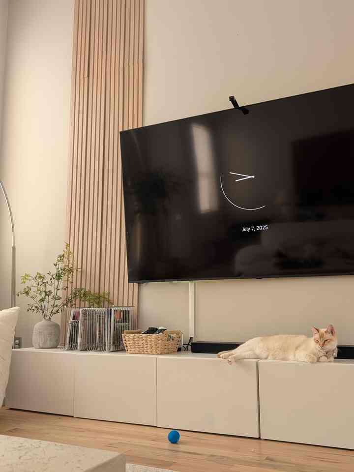 White and beige toned living room featuring a white BESTÅ cabinet with a relaxed cat lying on it, creating a cozy atmosphere