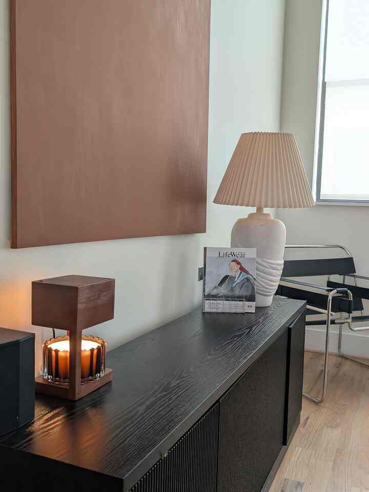 Brown-toned living room corner featuring a mid-century modern armchair and candle warmer creating a cozy atmosphere