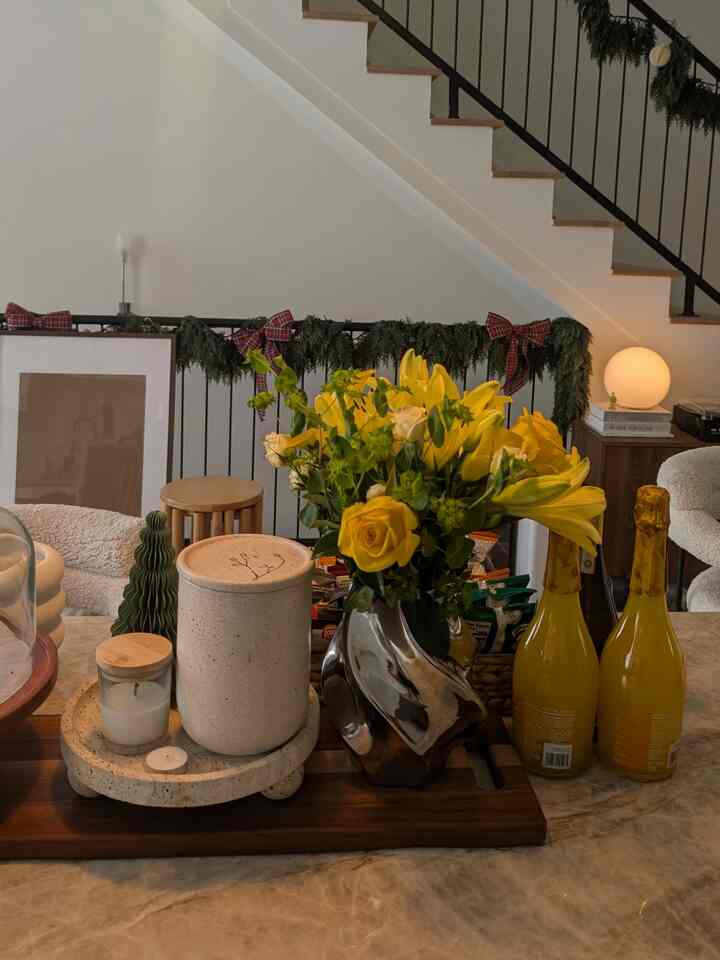 Cozy wood-tone living space with kitchen featuring yellow flowers and warm decor accents