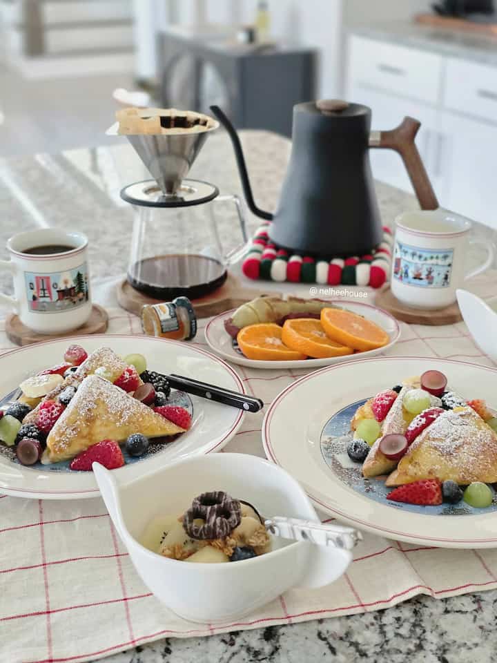 Bright white and gray toned kitchen space featuring a cozy home cafe style table with Christmas-themed mugs and drip coffee setup for a festive brunch vibe