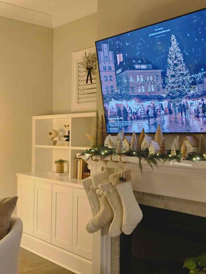 Natural and white toned living room featuring a fireplace with cozy Christmas stockings and decorations, warm festive ambiance
